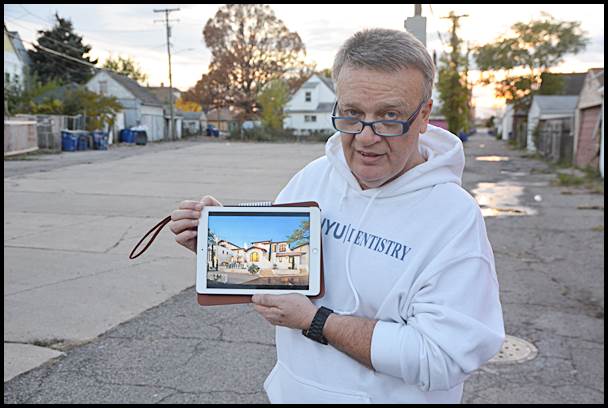 Dr. Sami Bilani holds up a model of a townhouse design he would like to build on an unused parking lot next to his dental office on Brombach and Florian.