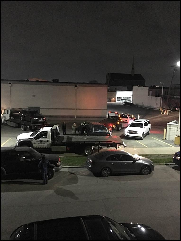 Three tow trucks from Breakthrough Towing surround a car to apparently prevent the owner of the car from moving his car out of the CVS lot on Holbrook and Jos. Campau. Photo by Tia Krawczyk.
