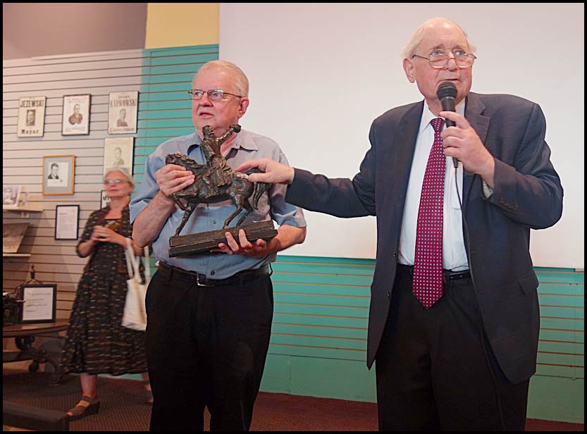 Former U.S. Senator Carl Levin presents a replica statue of Thaddeus Kosciuszko to Hamtramck Historical Museum Director Greg Kowalski at last week’s unveiling of the museum’s mural “Coming to Hamtramck.”