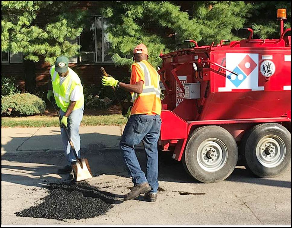 A Domino’s pothole repair crew hit the streets this week. No, that’s not pizza dough they are using to fill the potholes.