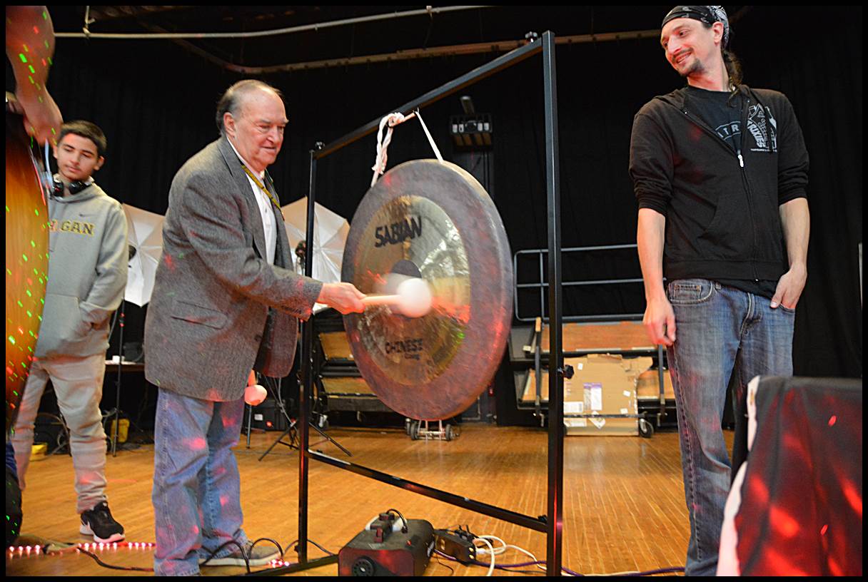 Hamtramck Public School Board Treasurer Dennis Lukas tries his hand at playing a gong that was one of several instruments donated by the Hamtramck Music Festival to the public school district. Organizers of the festival donated $5,000 worth of instruments and $5,000 to go toward a new public address system for the auditorium at Hamtramck High School.